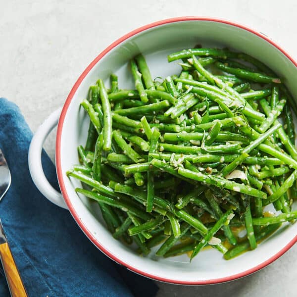 Green Bean Nicoise Salad in white bowl on table.