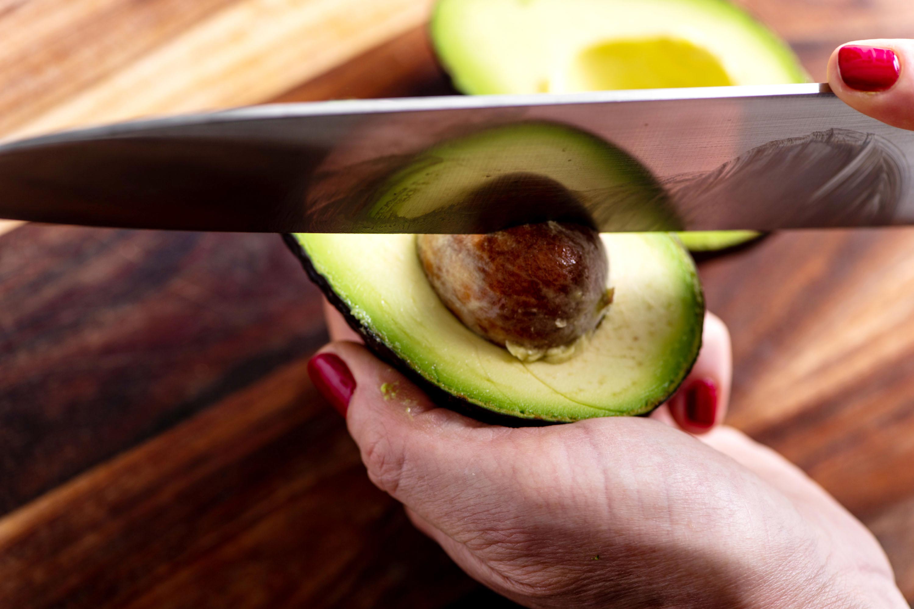 Woman removing the pit from avocado