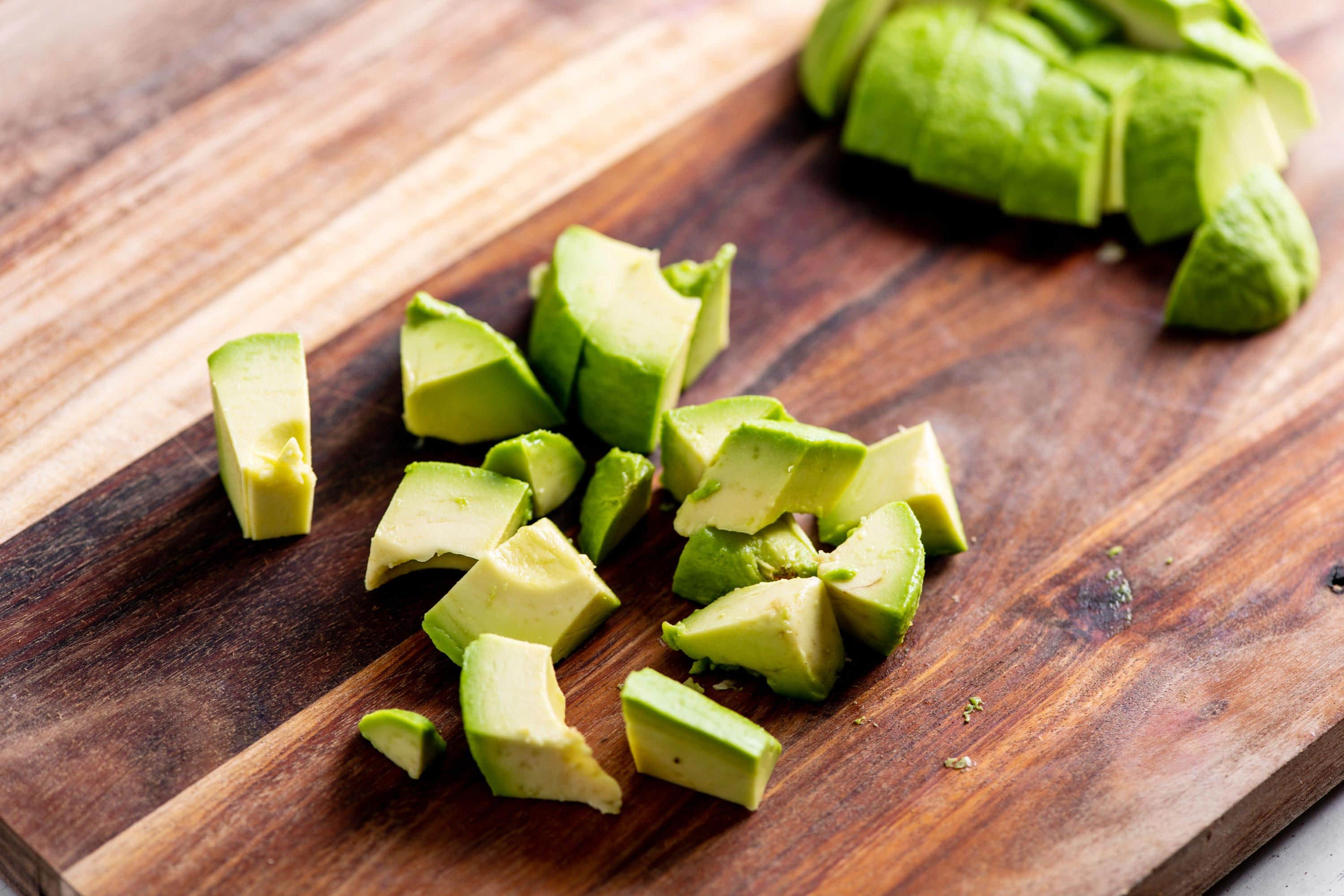 Cut avocados on a wooden board.