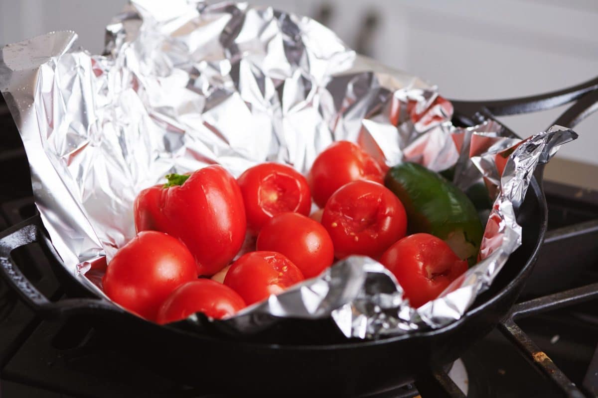 Tomatoes and peppers in a foil-lined pan.