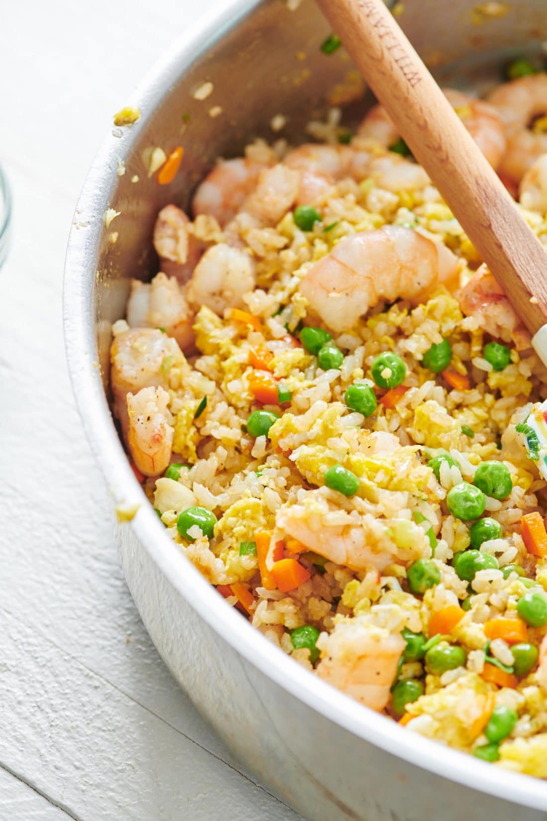 Wooden spoon in a pan of Shrimp Fried Rice.