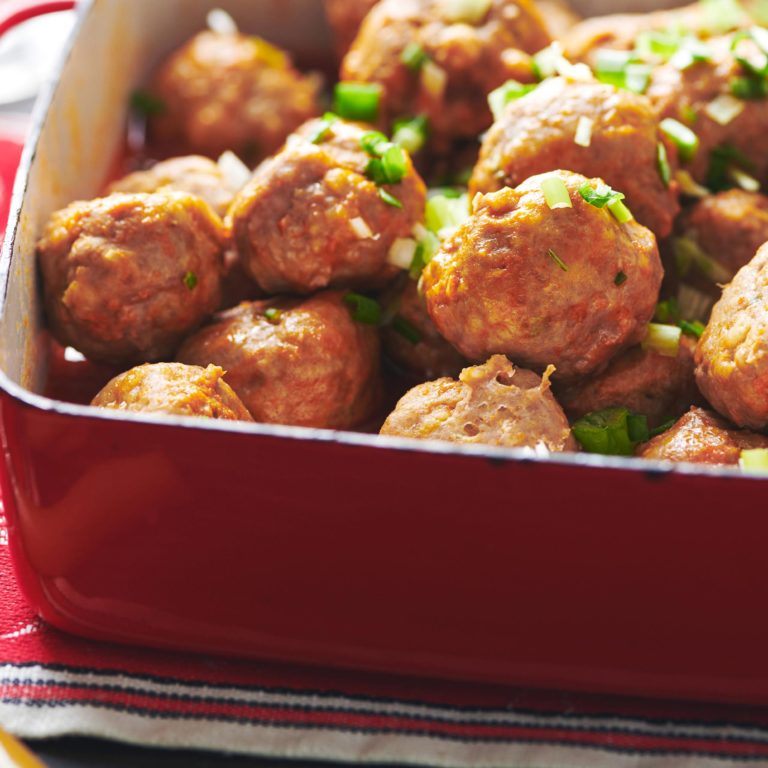 Buffalo Chicken Meatballs piled high in a red baking dish.