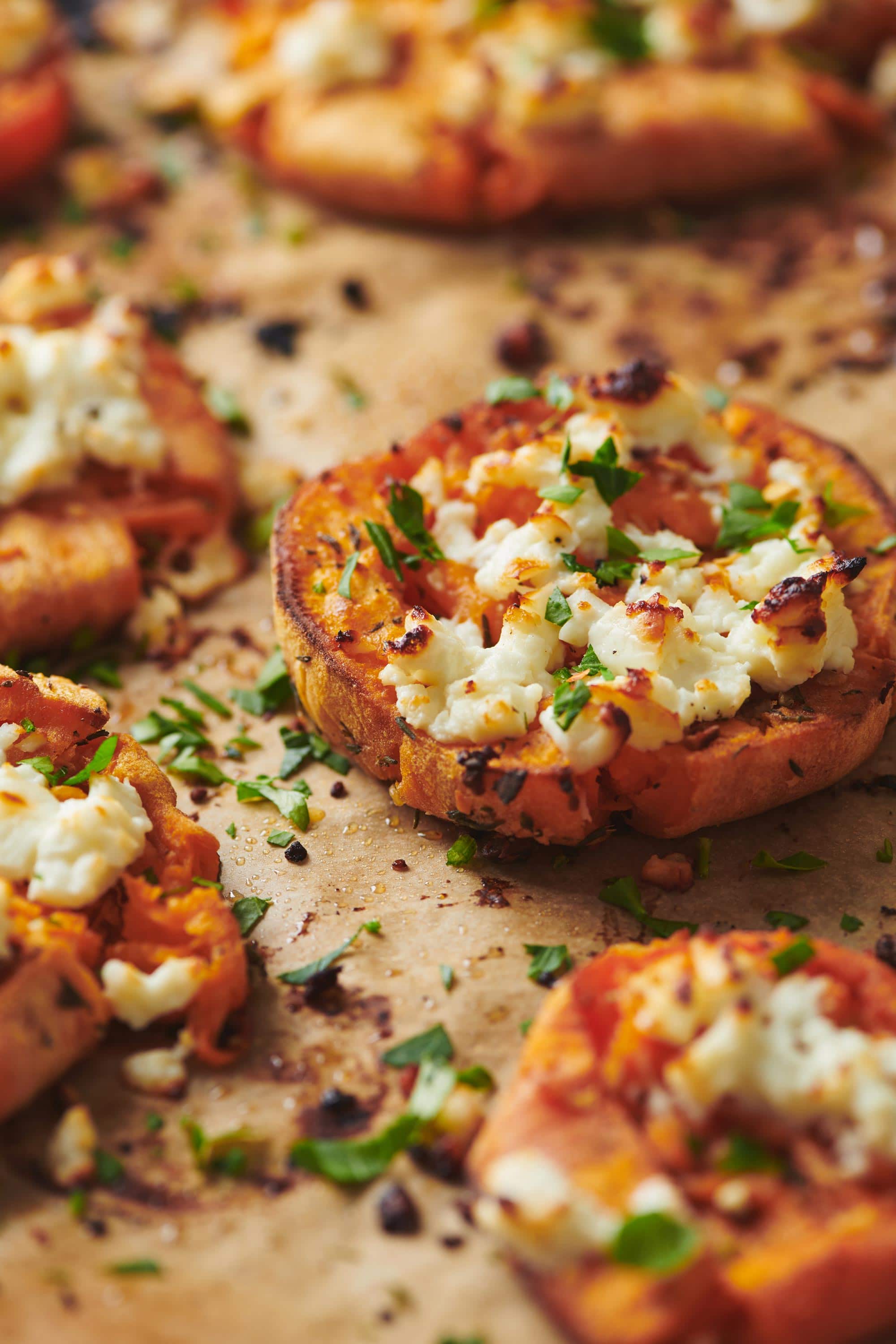 Smashed Garlic Butter Sweet Potatoes with Feta on parchment paper.