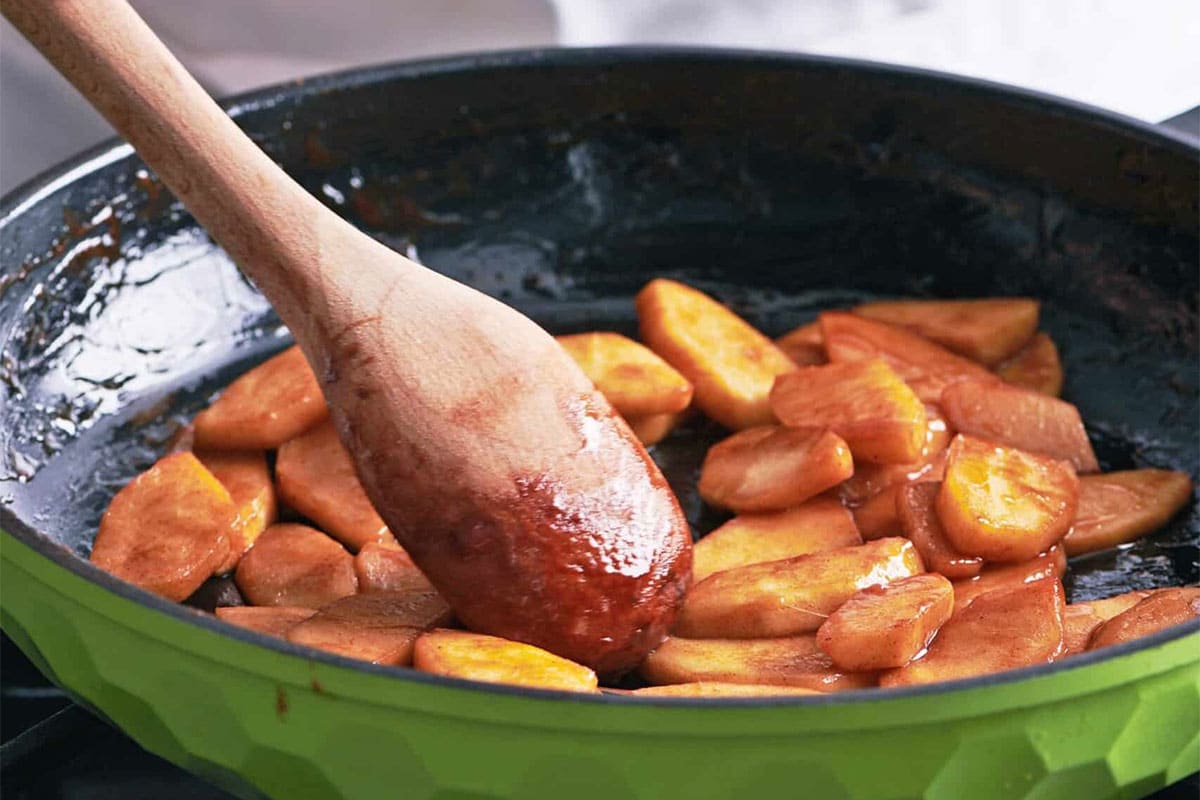 Sauteing apples in skillet on stove.