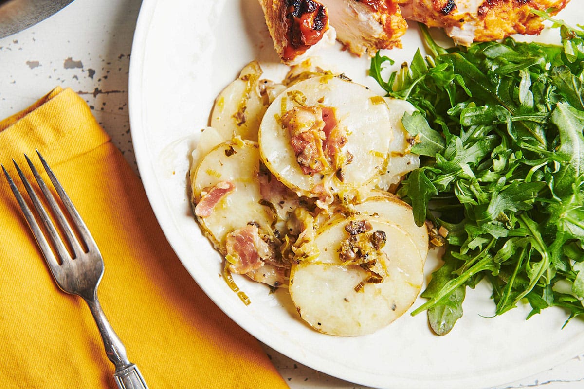 Dutch Oven Idaho Potatoes on plate with salad and chicken.