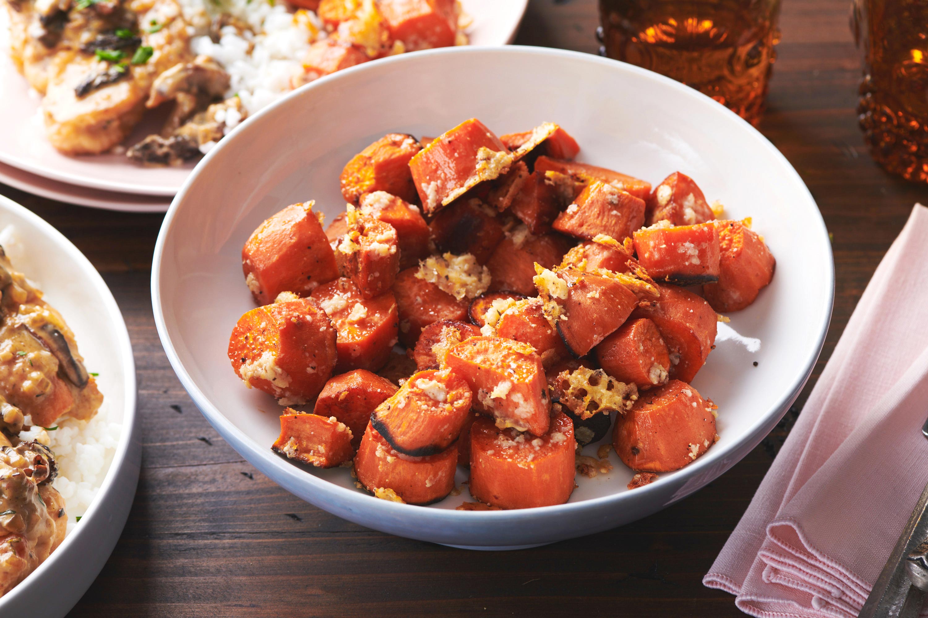 Bowl of Garlic-Parmesan Sweet Potatoes on a wooden table.