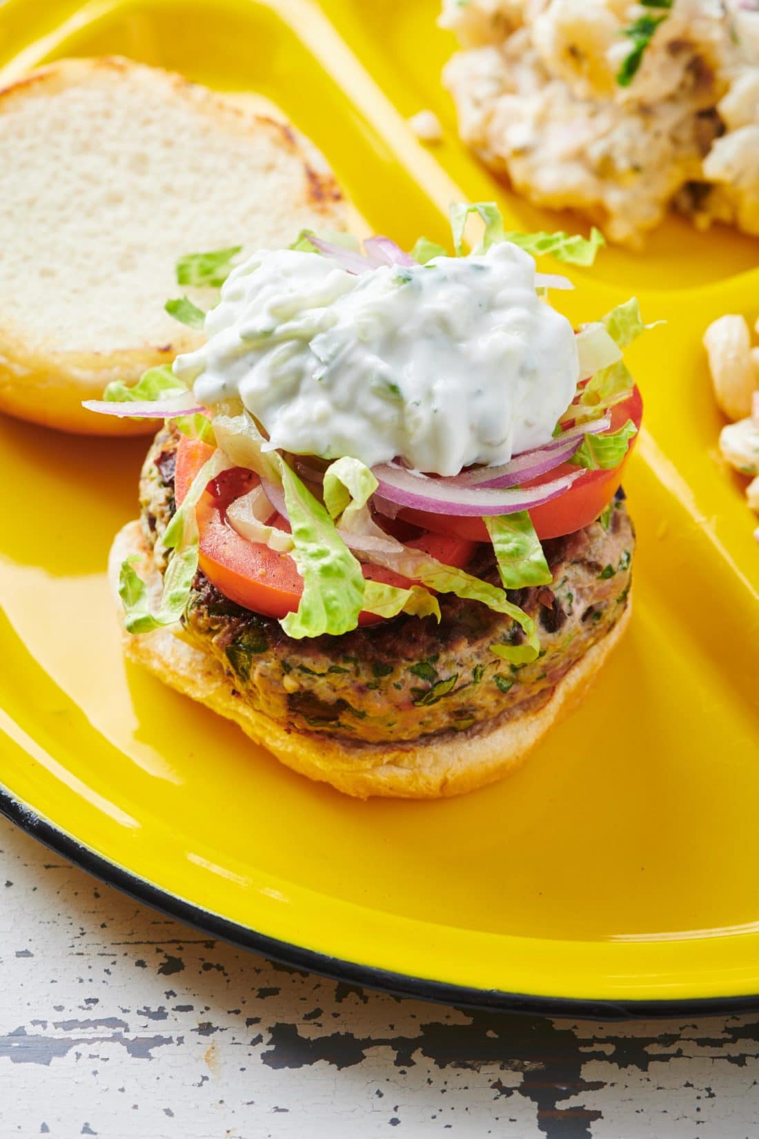 Greek Turkey Burger on a yellow plate.