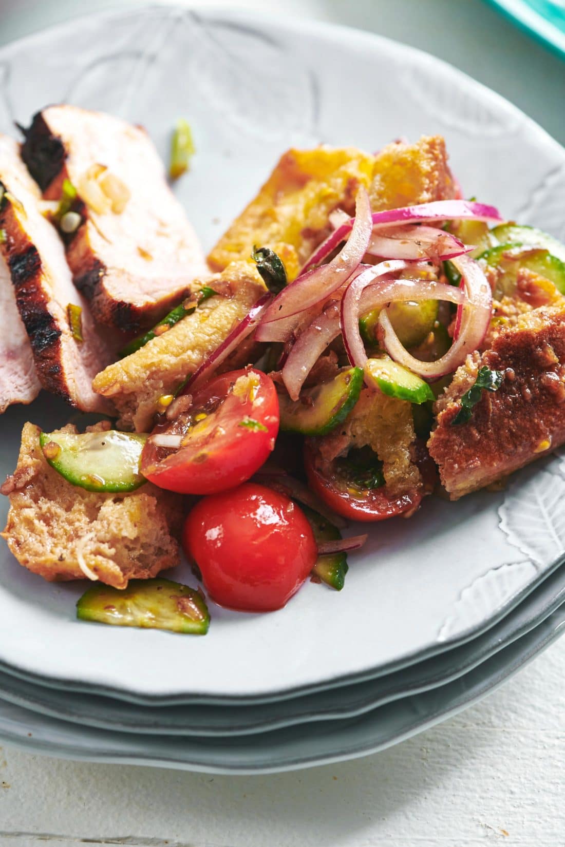 Soy-Ginger Pork Chop on a plate with panzanella. 
