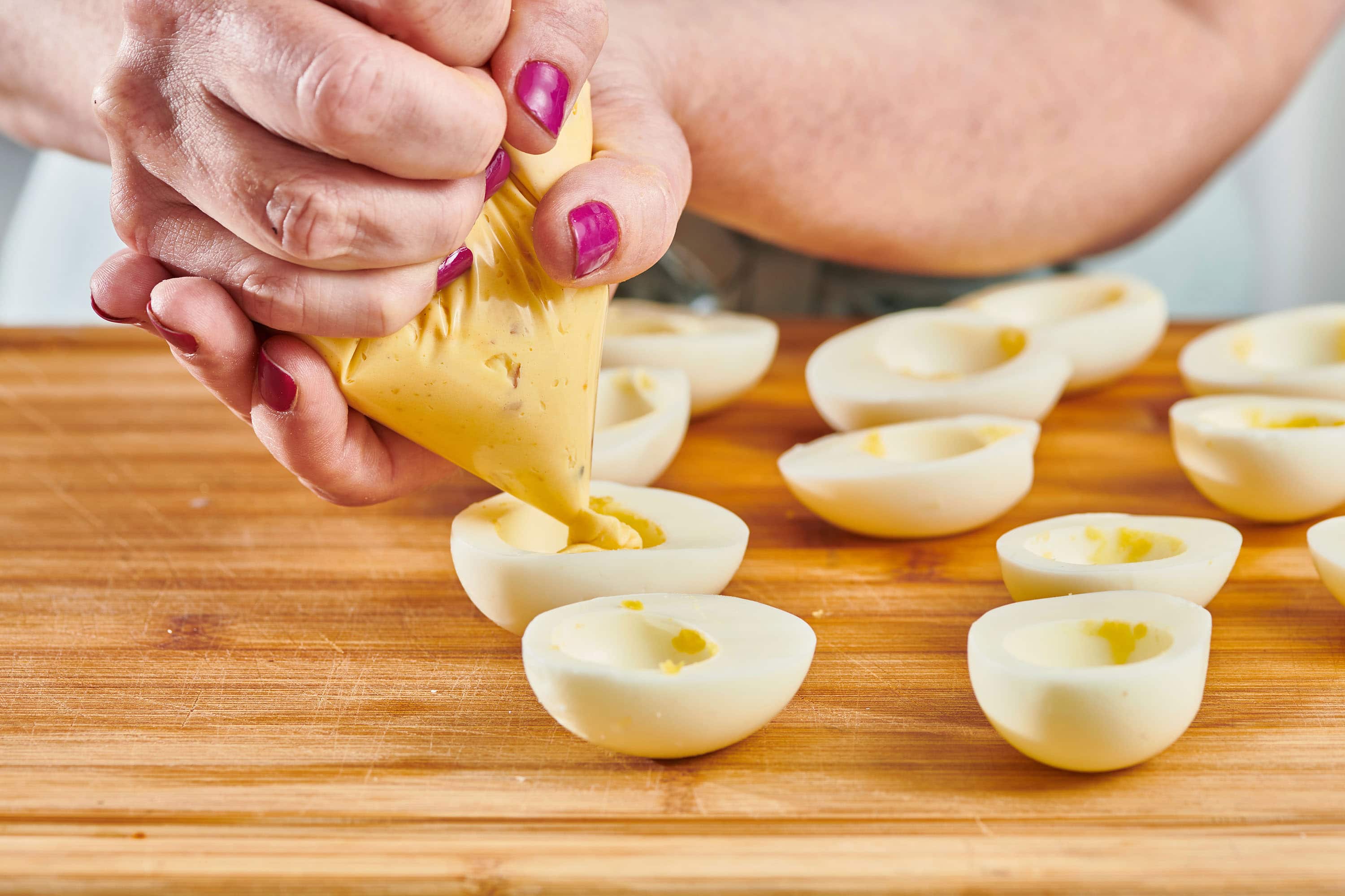 Woman piping filling into Deviled Eggs