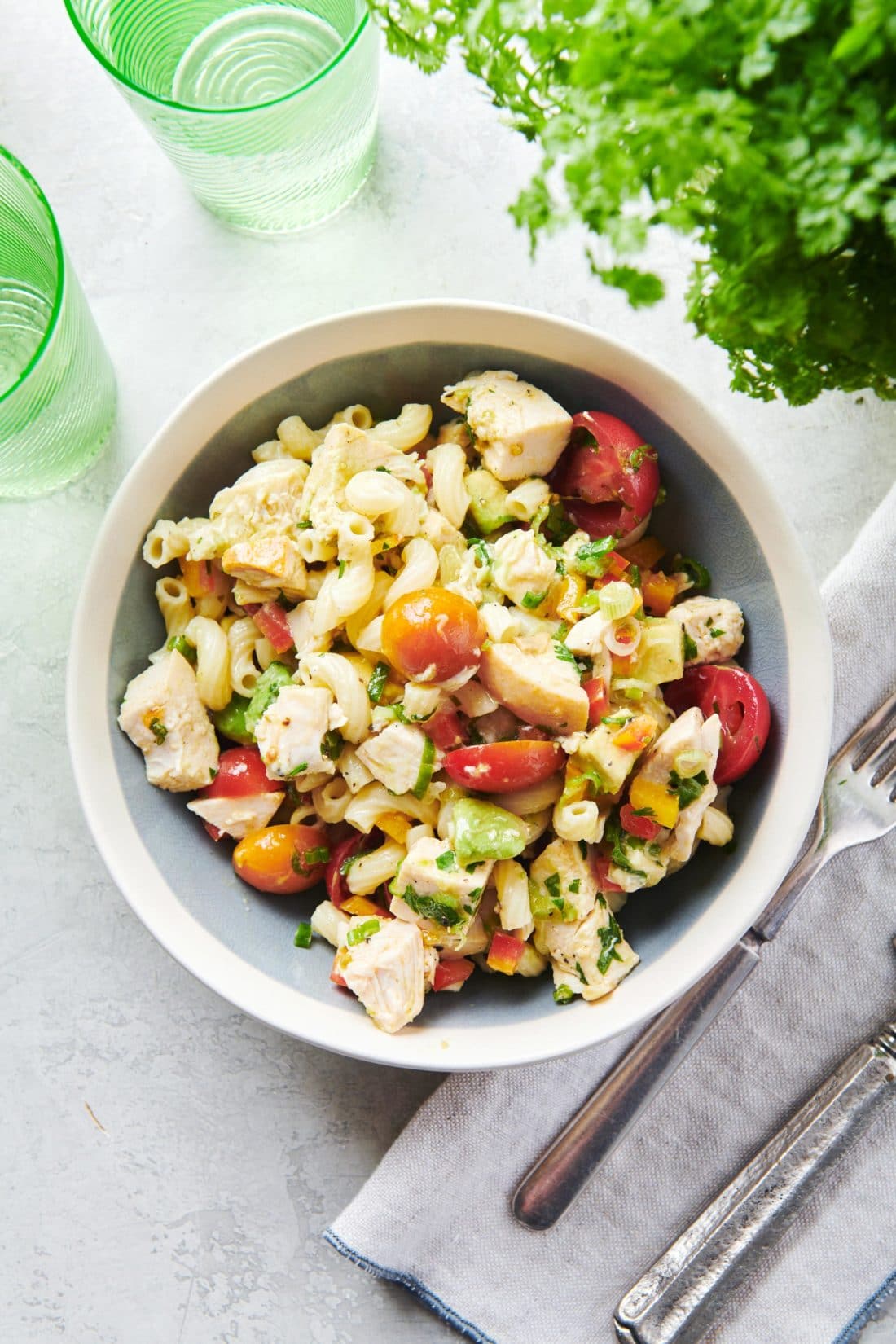 Bowl of Pasta Salad with Chicken, Avocado and Tomato.