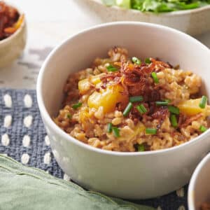 White bowls of Farrotto with Golden Beets, Mixed Herbs and Crispy Shallots.