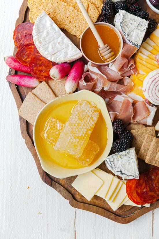 Honeycombs in a bowl on a grazing board.