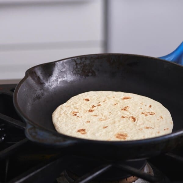 Tortilla in a skillet on a stovetop.