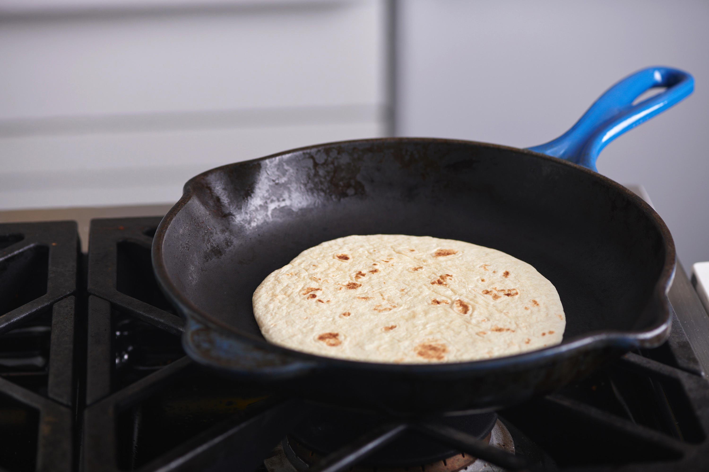 Tortilla in a skillet on a stovetop.