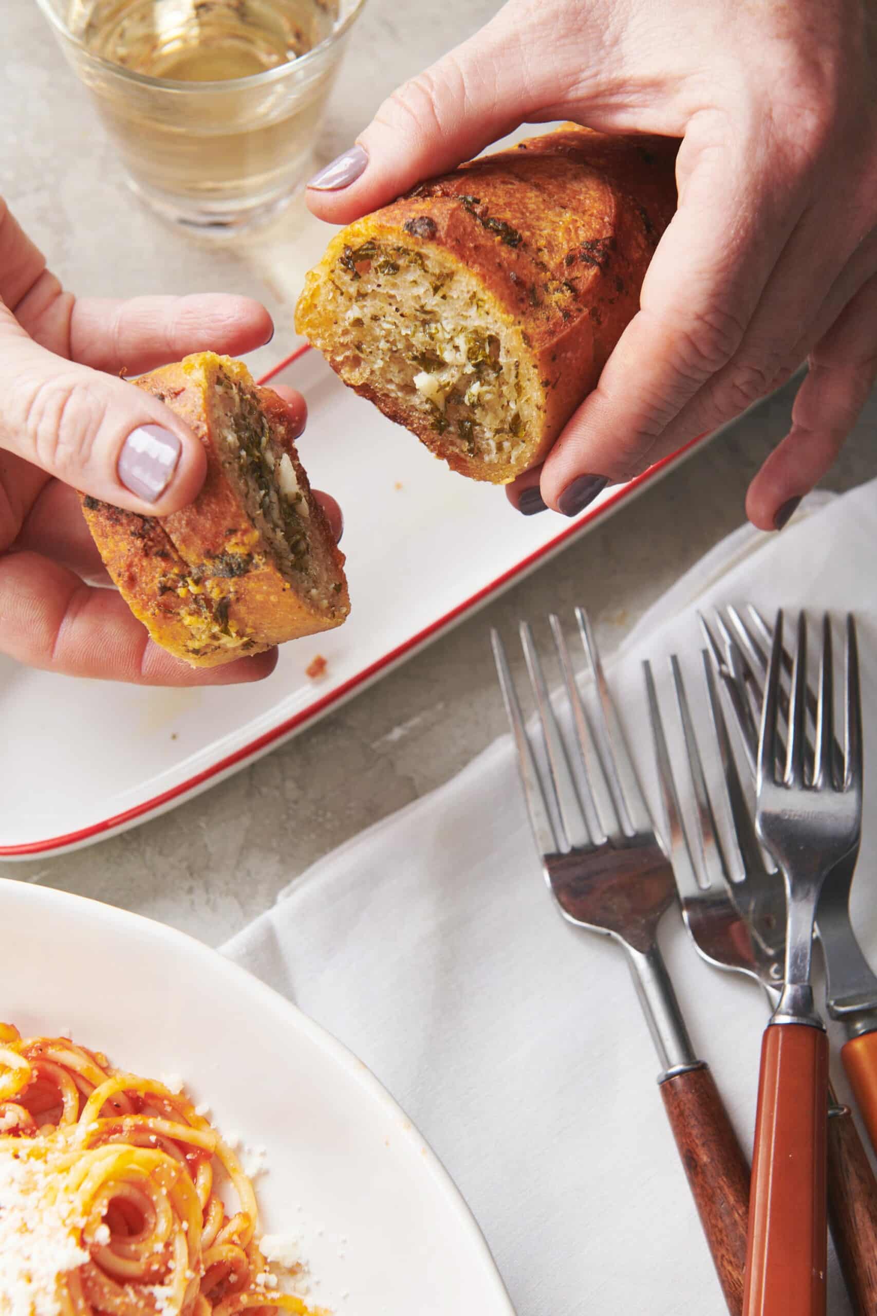 Woman pulling apart slices of Ranch Garlic Bread.