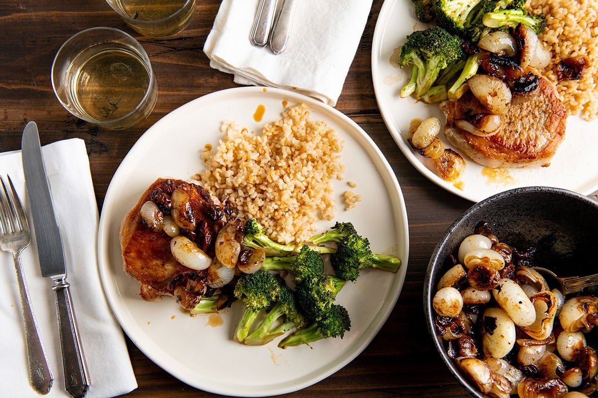 Plate of couscous, broccoli, and meat topped with Braised Cipollini Onions with Dried Cherries.