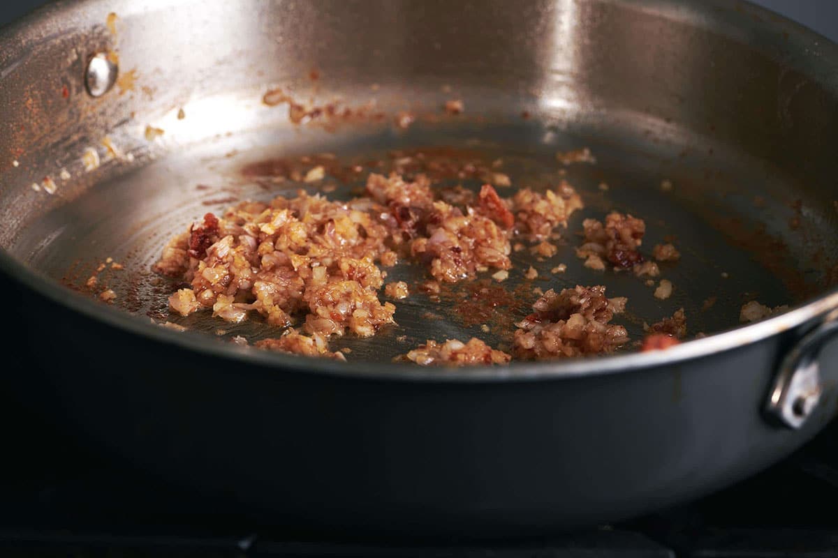 Sauteing garlic and shallots in pan on stove.
