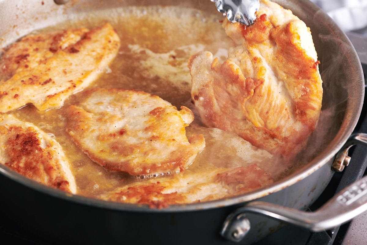 Cooking chicken cutlets in pan.