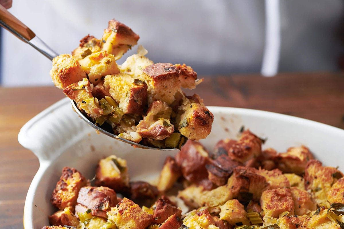 Spoon scooping Thanksgiving Stuffing from dish.