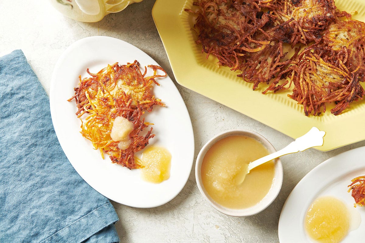 Potato pancakes on plate and platter with apple sauce