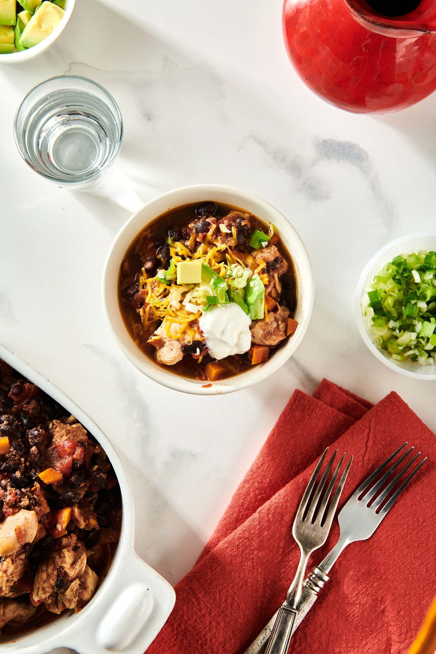 White bowl of Chicken Chili on a marble surface.