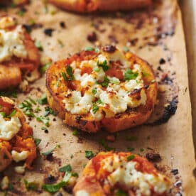 Smashed Garlic Butter Sweet Potatoes with Feta on baking sheet.