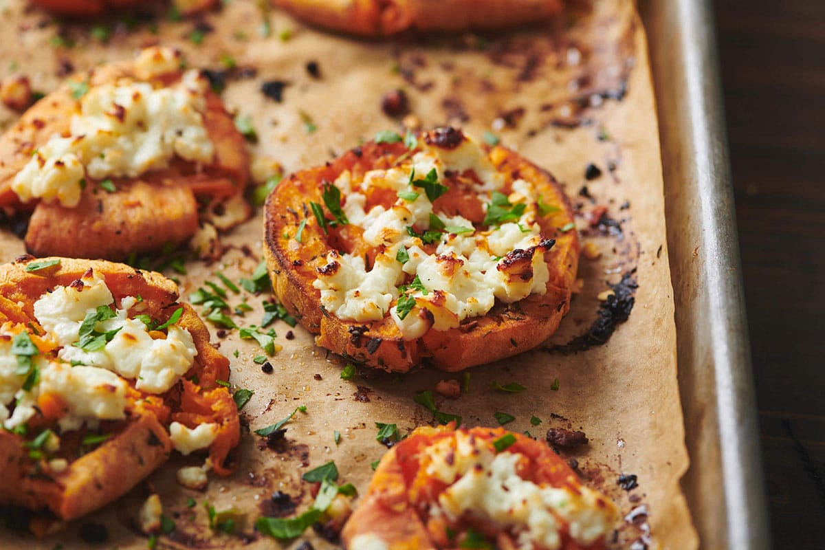 Smashed Garlic Butter Sweet Potatoes with Feta on baking sheet.