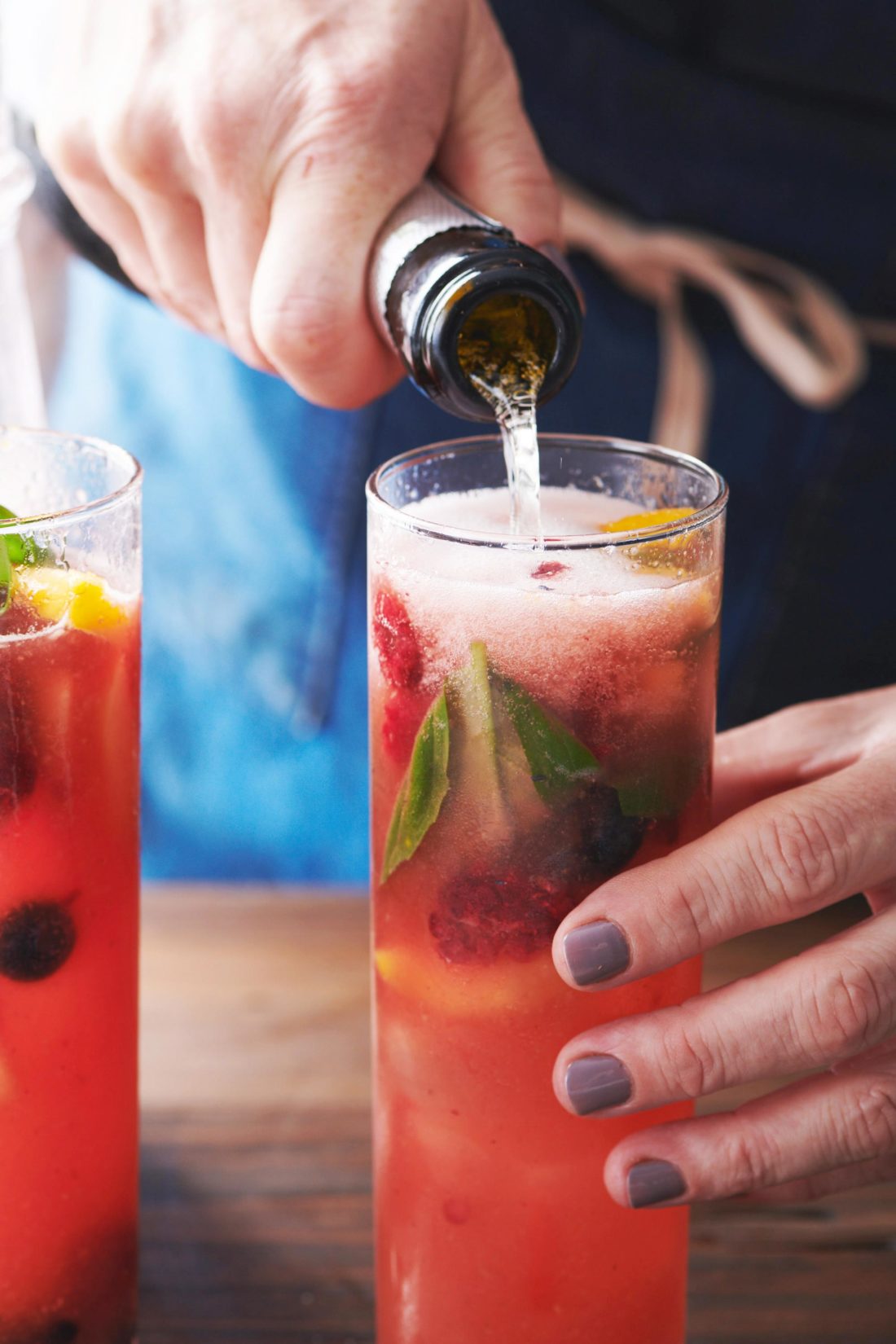 Woman pouring sparkling liquid into Fruit and Berry Sangria.