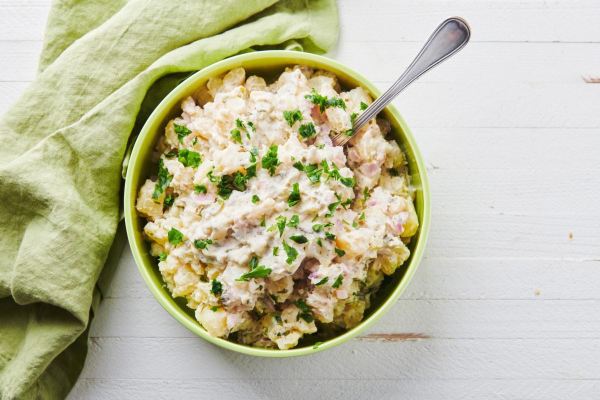 Spoon in a bowl of Potato Salad.