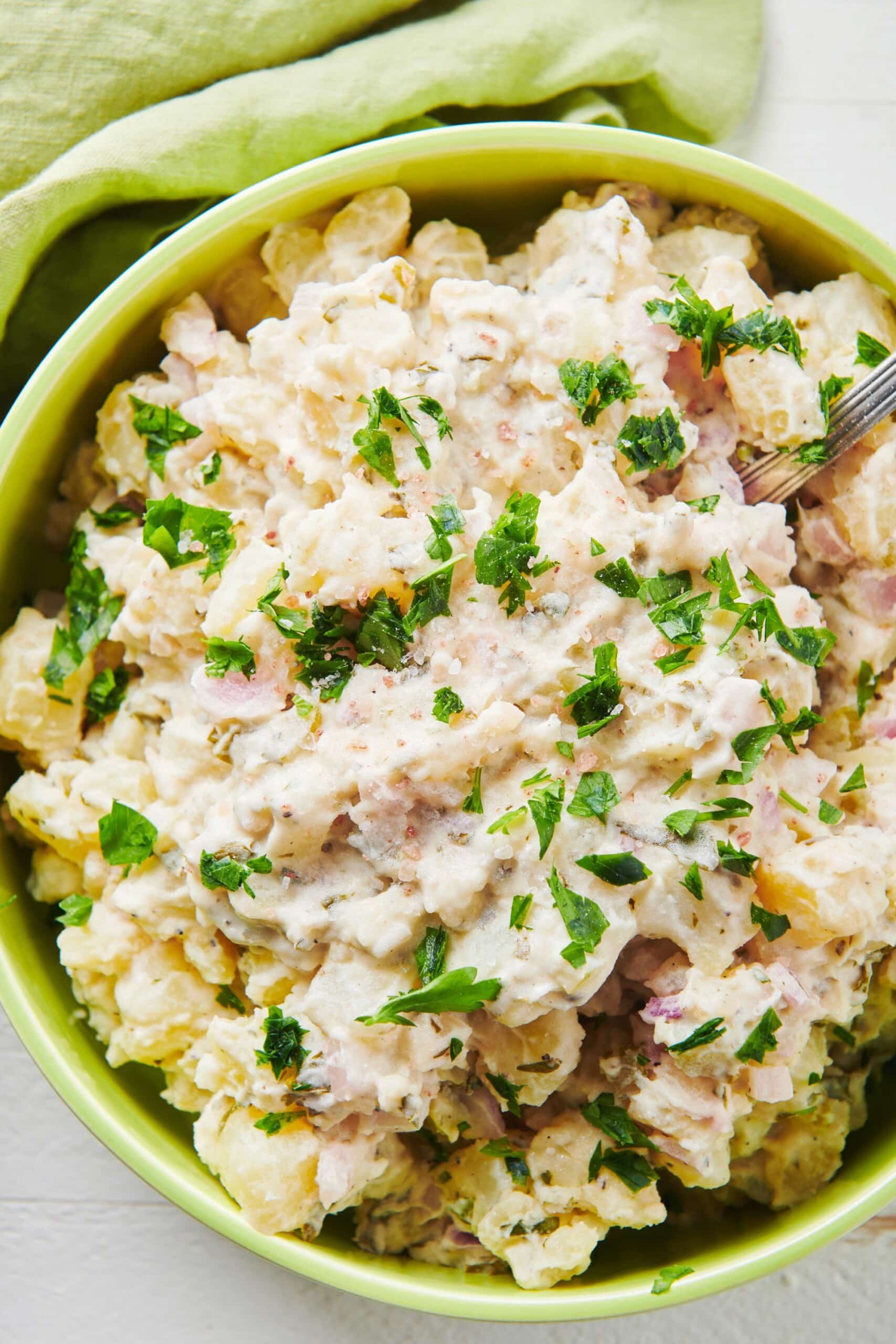 Potato Salad topped with chopped herbs in a bowl.