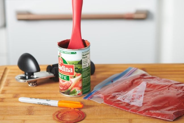 Ziploc bag of Tomato Paste next to a can of tomato paste.