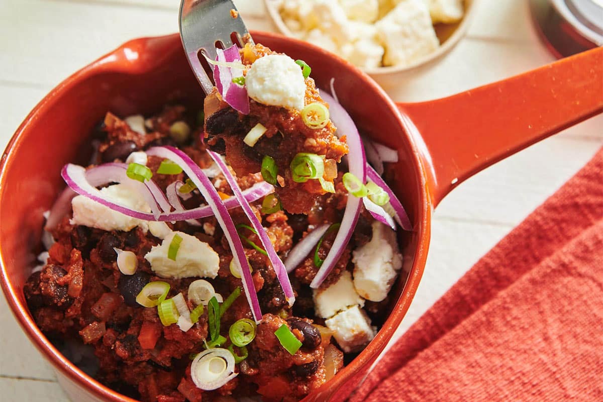Fork grabbing some Beef, Black Bean, and Jalapeno Chili from a bowl.