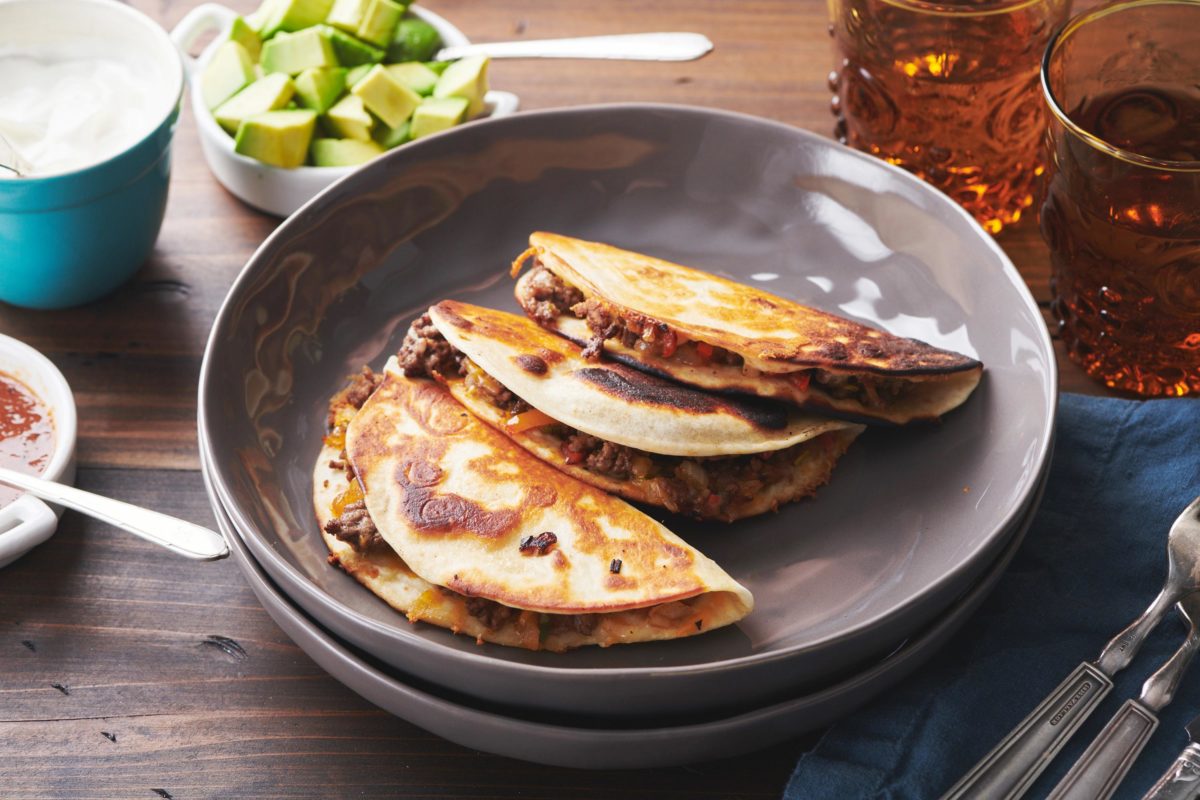 Cheesy Ground Beef and Vegetable Quesadillas on two stacked plates.