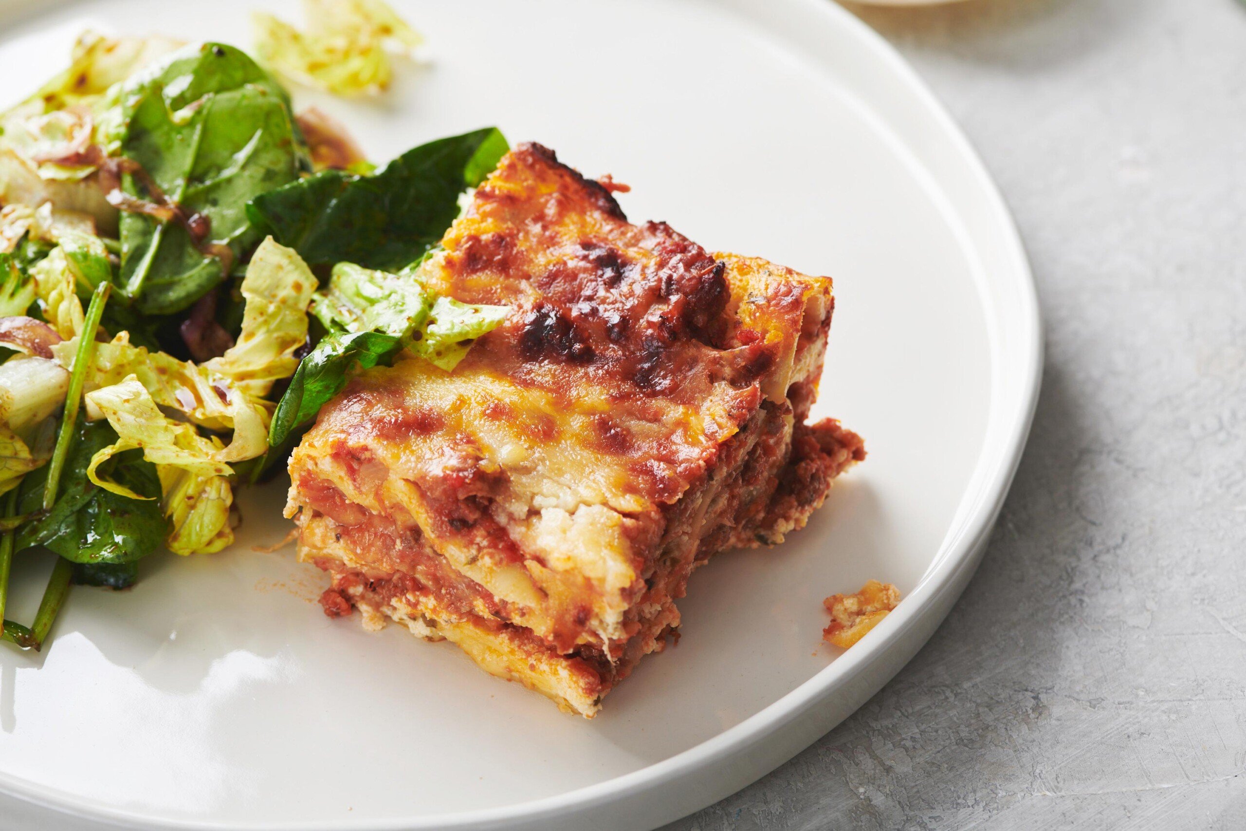 Slice of Classic Cheesy Beefy Lasagna on a white plate.