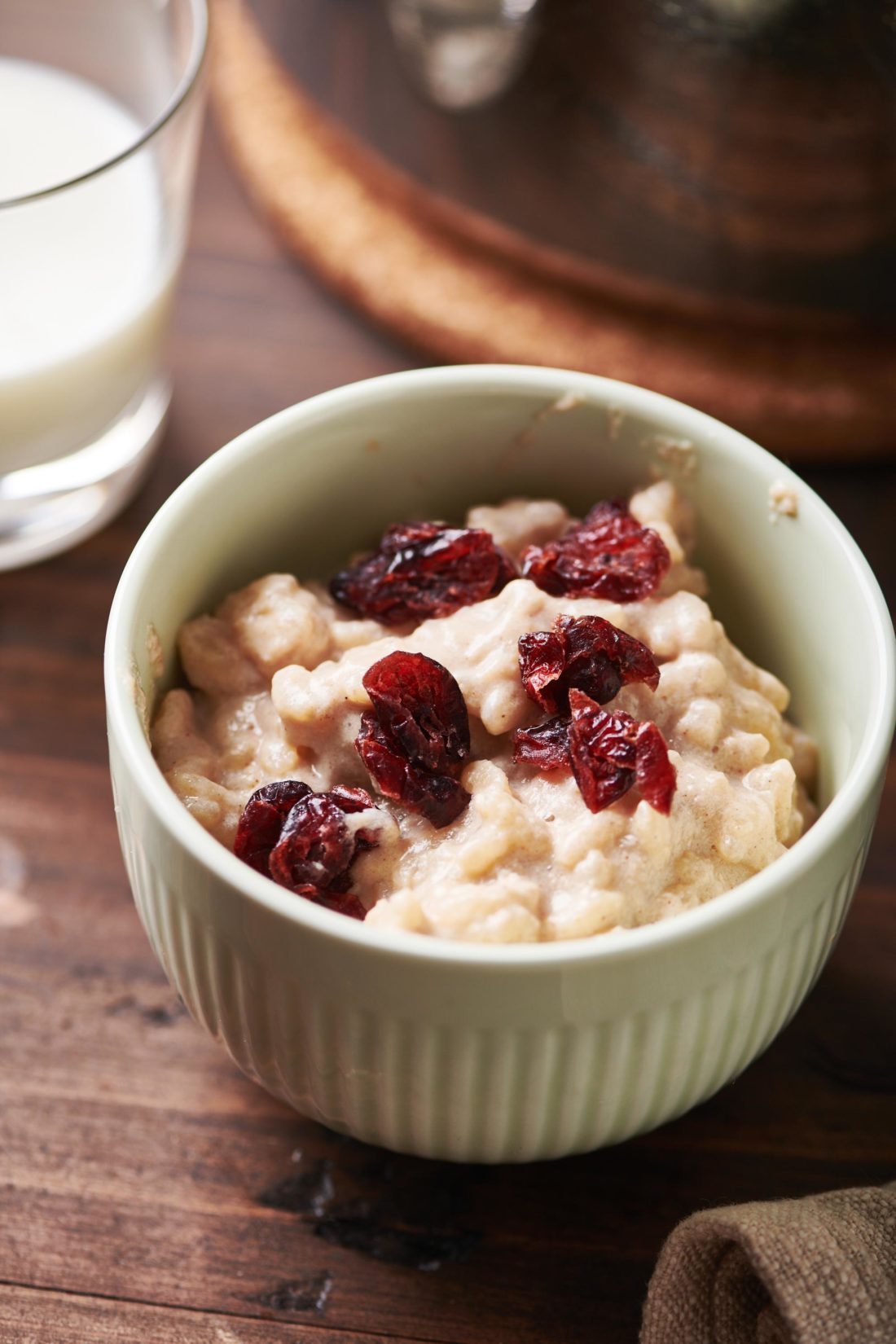 Small bowl of Creamy Rice Pudding topped with dried cranberries.