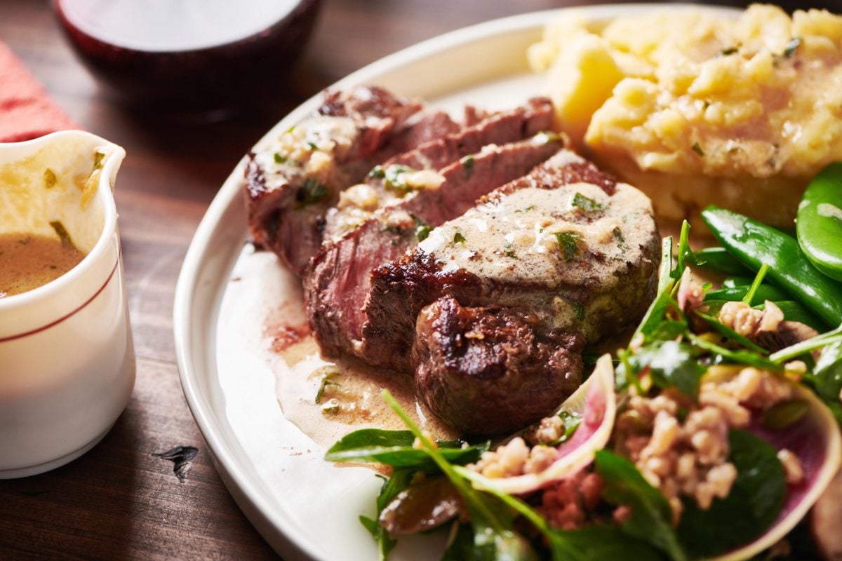 Sliced Filet Mignon with a Creamy Parmesan Mustard Sauce on a plate.