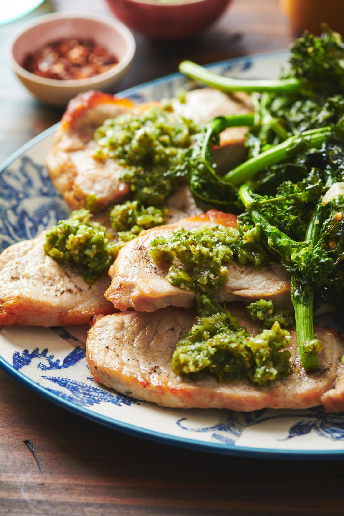 Pork Chops with Italian Salsa Verde and broccoli rabe on a platter.