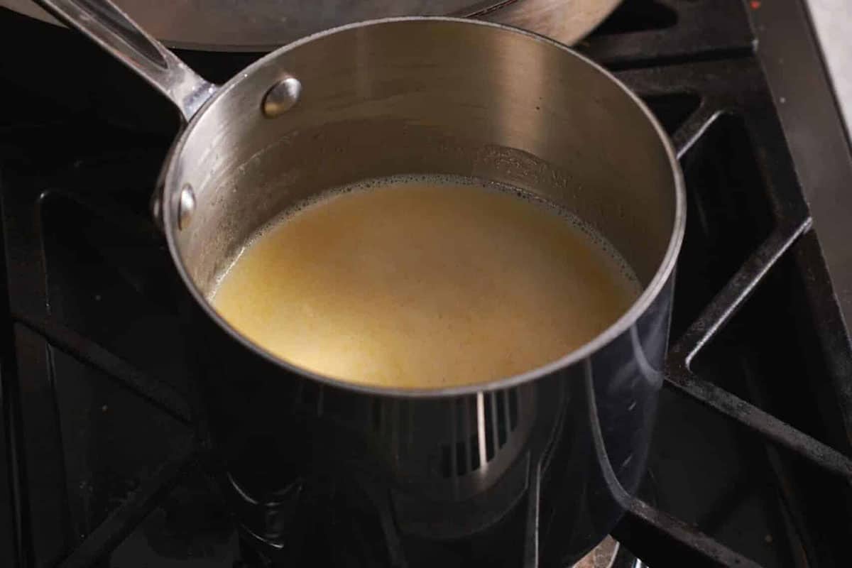Warming milk and cream in saucepan on stove.