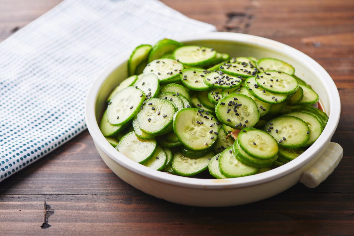 Japanese Cucumber Salad in a white bowl on a wooden table.
