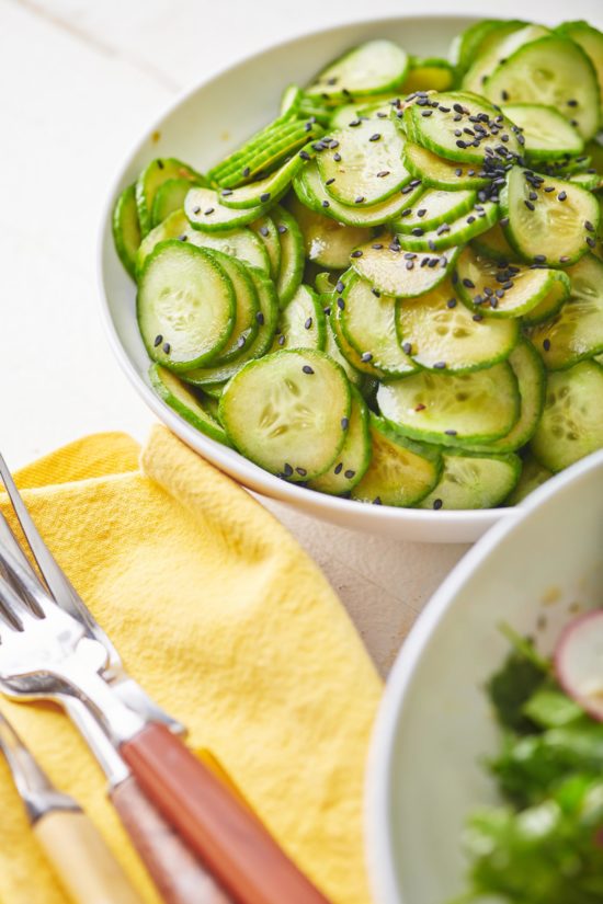 Japanese Cucumber Salad on a table with a bowl of a different salad.