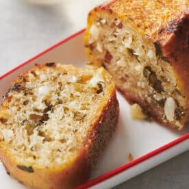 Sliced ranch-flavored garlic bread on white and red dish.