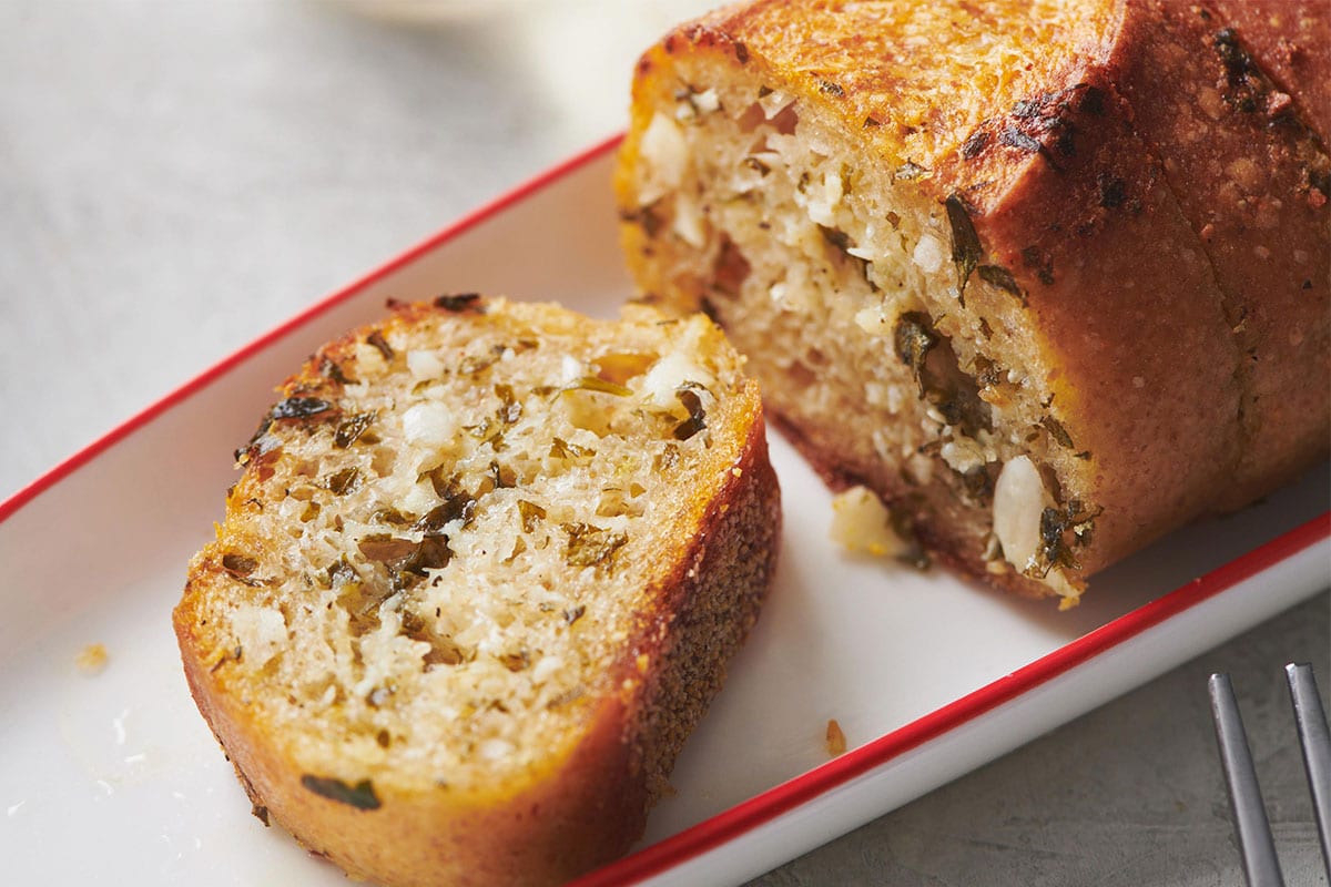 Sliced ranch-flavored garlic bread on white and red dish.