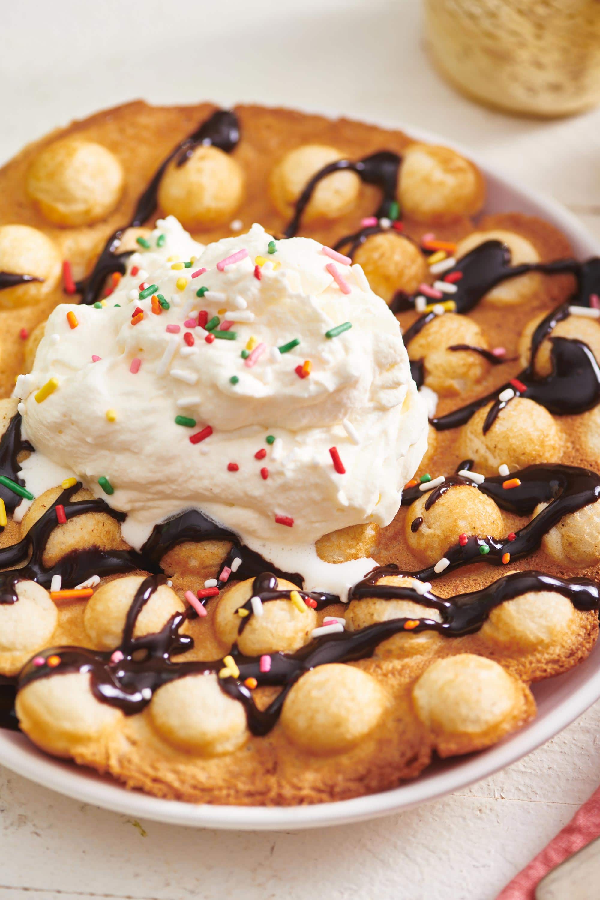 Bubble Waffles with chocolate sauce and ice cream with sprinkles.