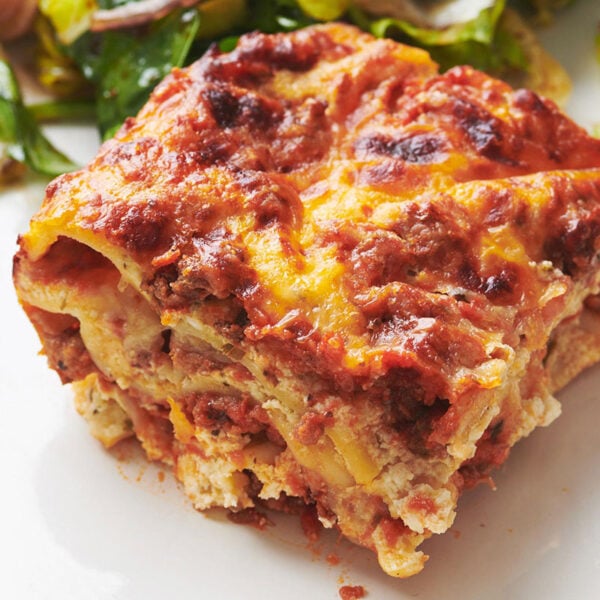 Slice of Lasagna on a white plate.