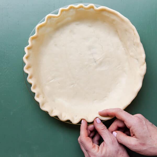 Forming pie crust in round pie plate.