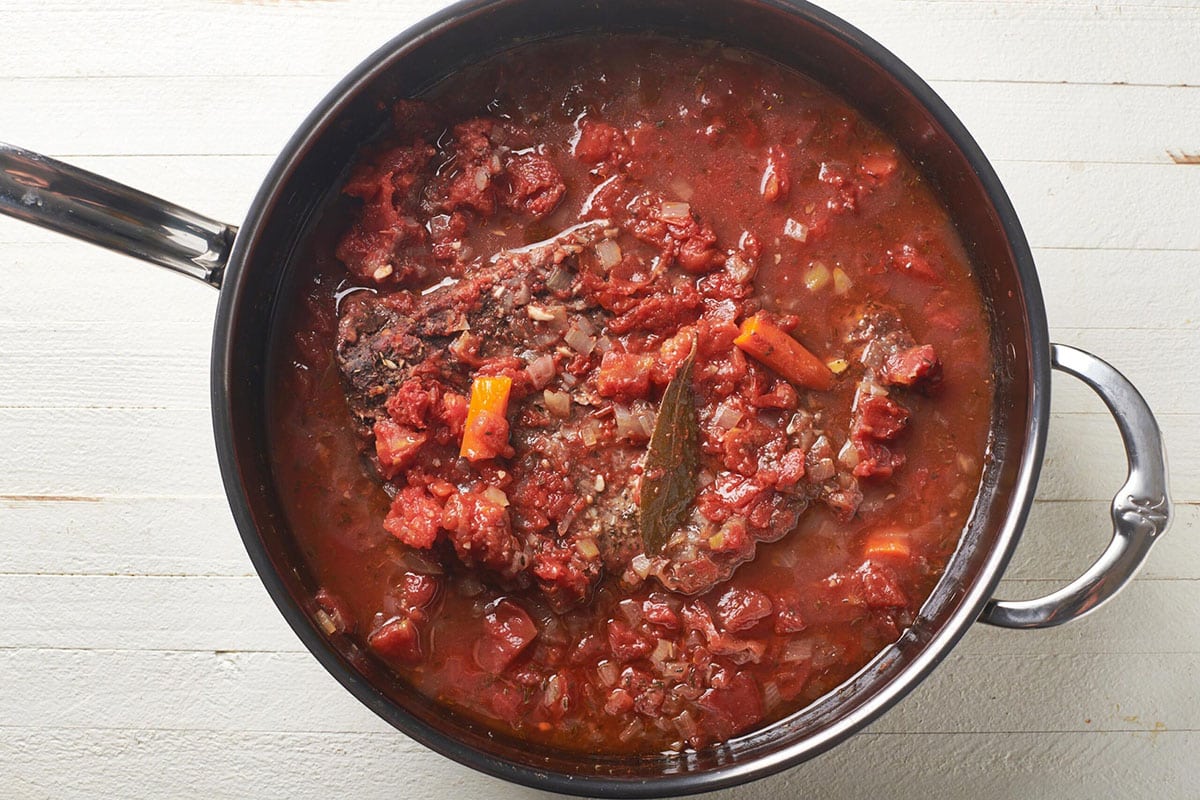 Pan filled with Jewish brisket cooking in tomato sauce.
