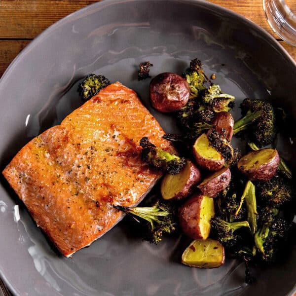 Baked salmon, potatoes, and broccoli on grey plate.