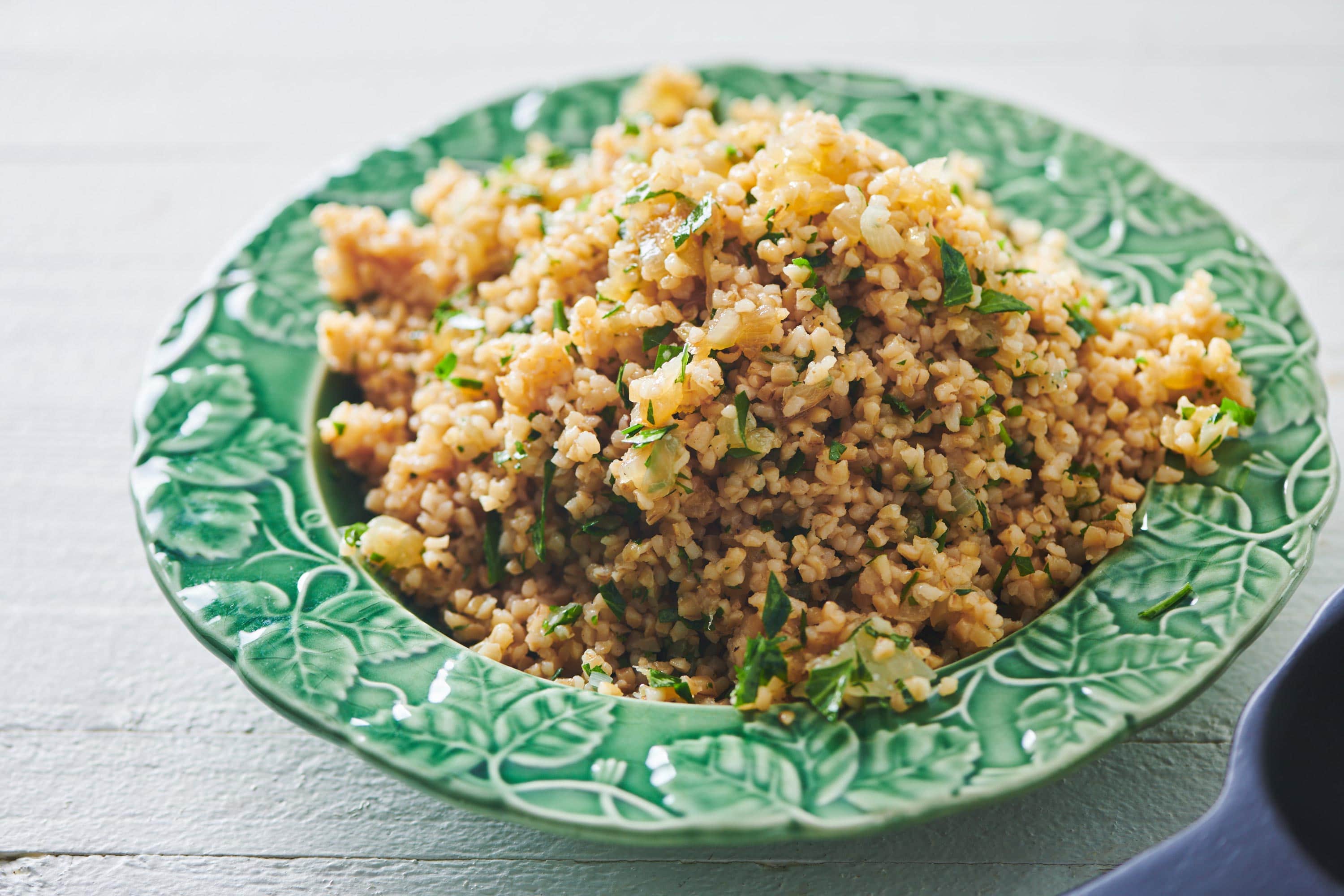Bulgur Wheat with Caramelized Onions and Parsley in green bowl.