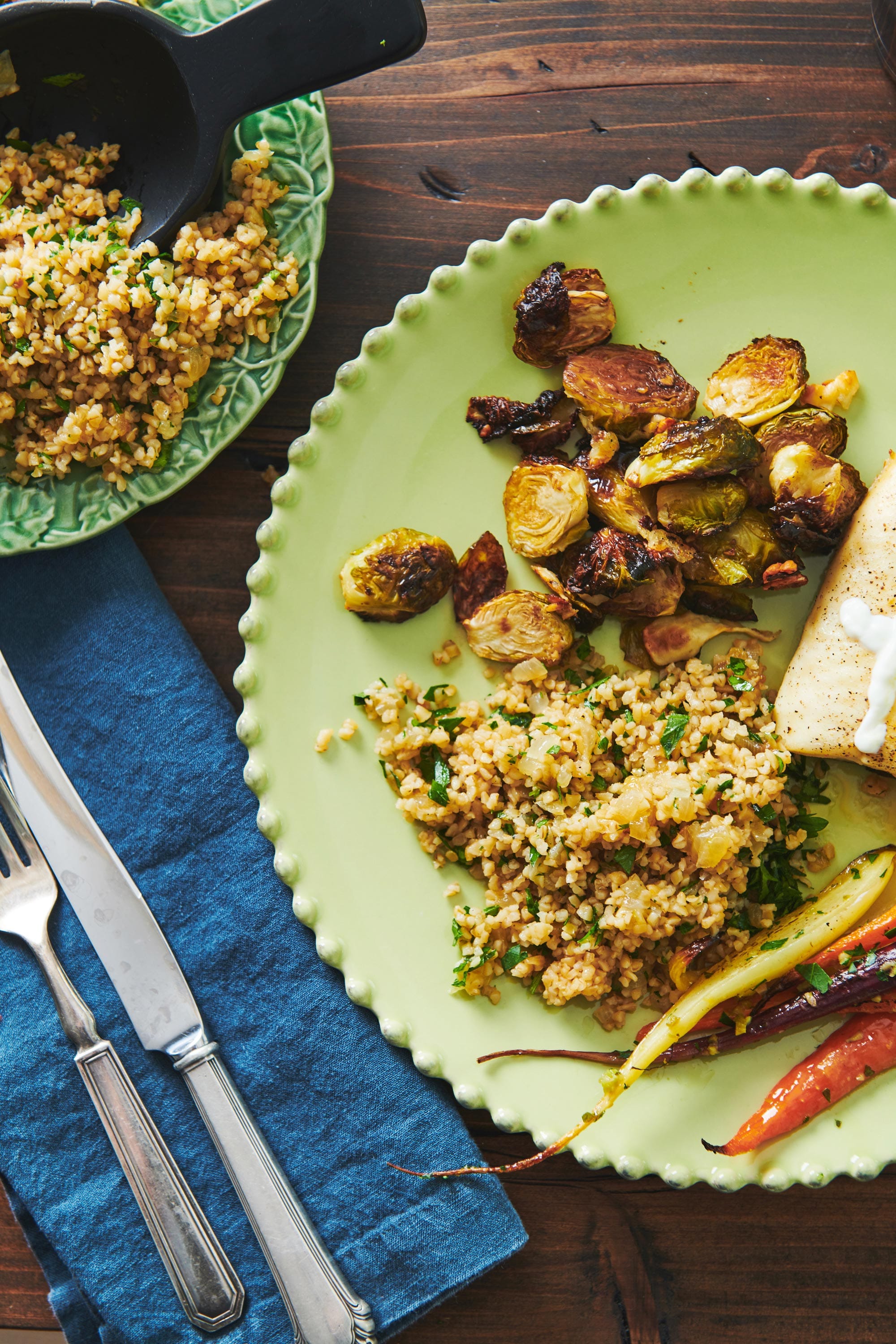 Bulgur Wheat with Caramelized Onions and Parsley on a plate with brussels sprouts, and carrots.