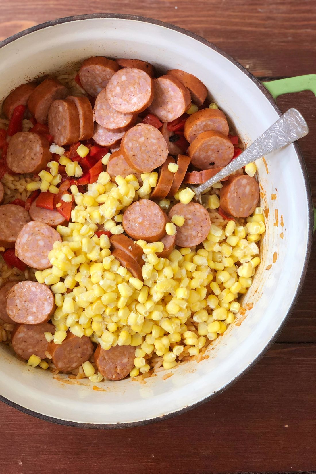 Bowl of corn, red pepper, and and sliced Zatarain\'s Cajun sausage.